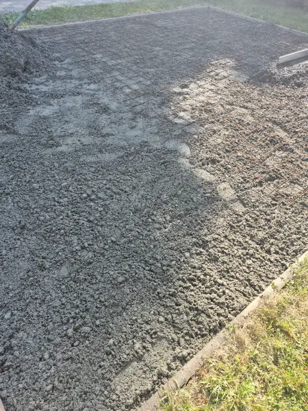 A friss beton terítése a vashálóra.