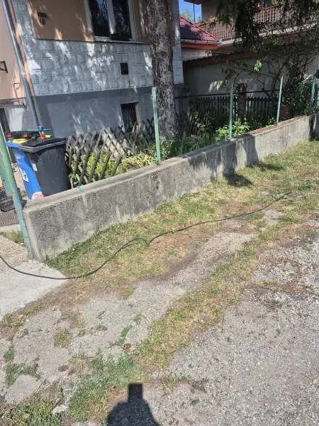 A kerítésszakasz a lécezés előtt – csak a betonlábazat áll.