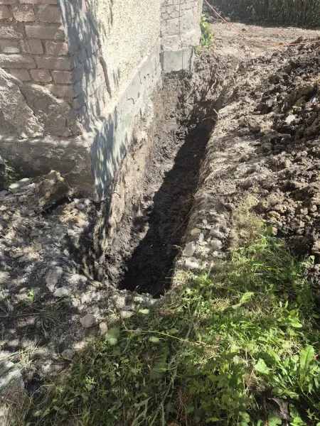 Keskeny árok a téglafal mentén.