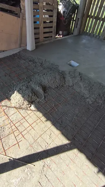 A friss beton terítése a vashálóra.