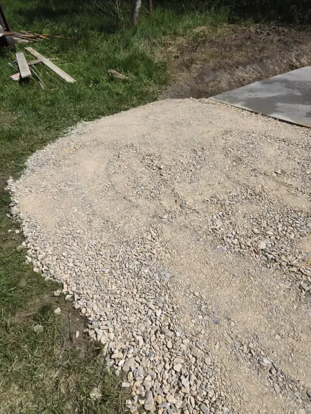 A zúzottkő ágyazat a betonfelület mellett.
