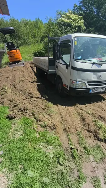 A minikotró a platóra rakodja a kitermelt földet.